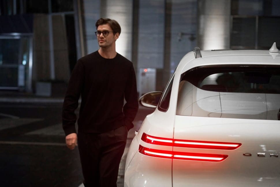 Man stands next to Genesis GV70.